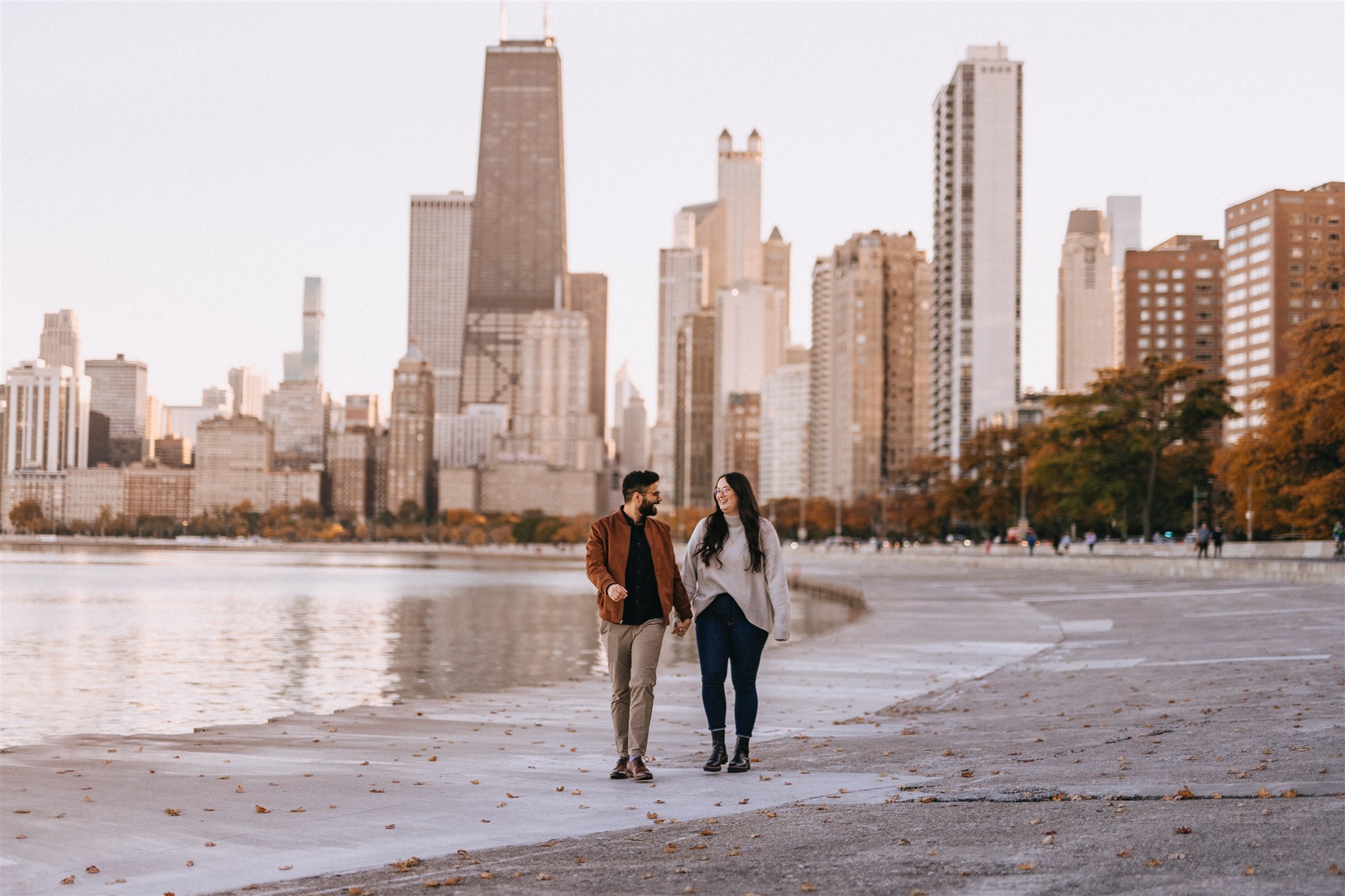 couple walks in front of chicago skyline at north avenue beach
